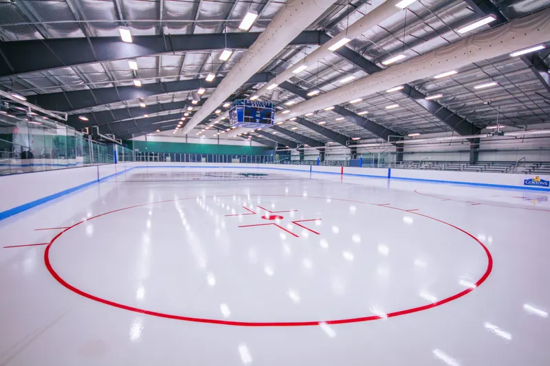 Red face-off circle on a bright indoor sheet under LED arena lighting