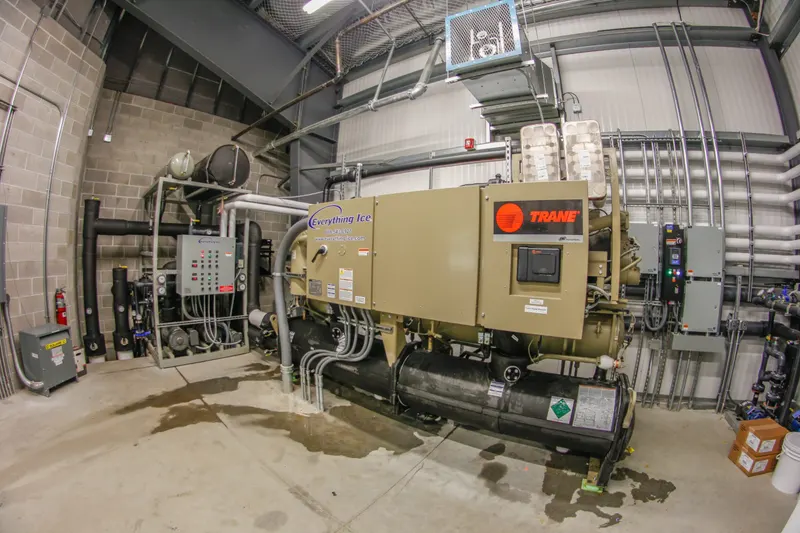 Packaged ice rink chiller and refrigeration piping in a mechanical room