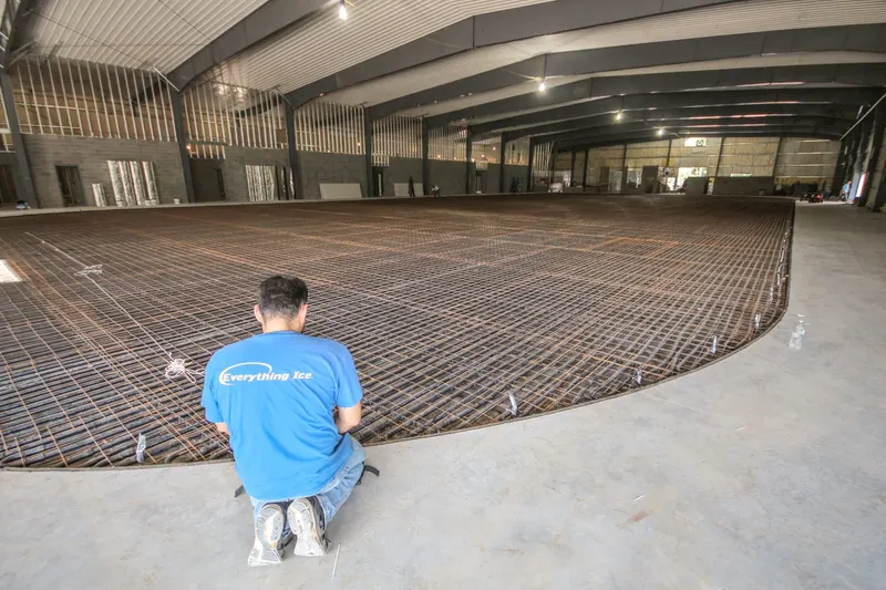 Rink floor piping grid laid out across a slab before the concrete pour