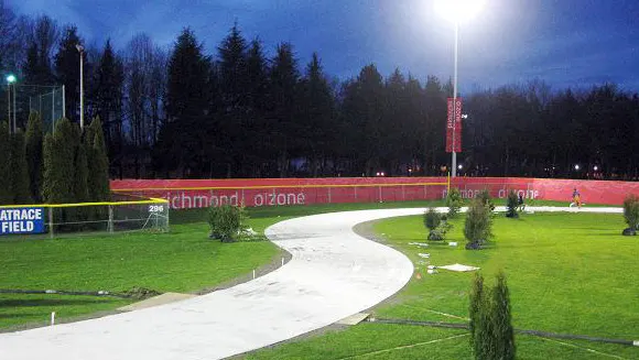 Winding outdoor ice skating track lit at night through a park