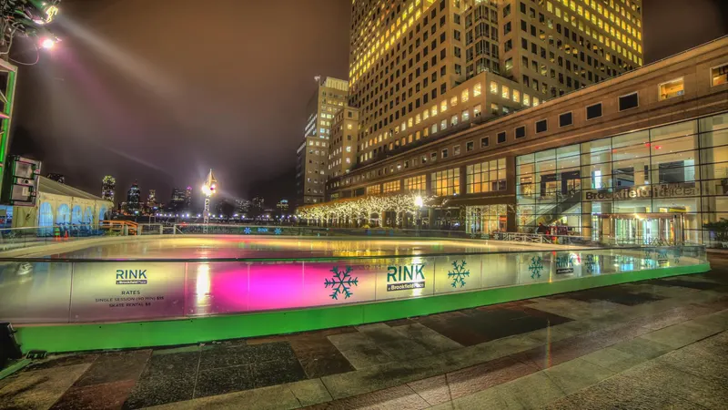 Outdoor rink glowing at night beneath city skyscrapers