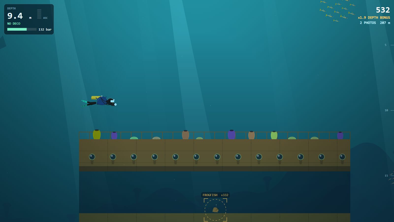 A diver above a sunken ship hull with portholes and sponges on the deck; below the deck a swim-through, where a viewfinder ring marks a frogfish worth 332 points